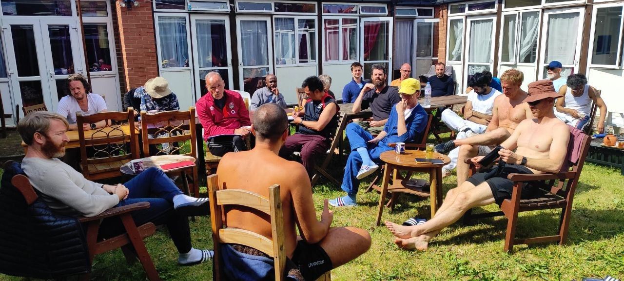 Men talking together in a garden between sessions